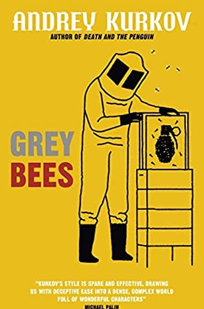 Cover image of Grey Bees by Andrej Kurkov shows a beekeeper lifting a comb from a hive on a bright golden yellow background